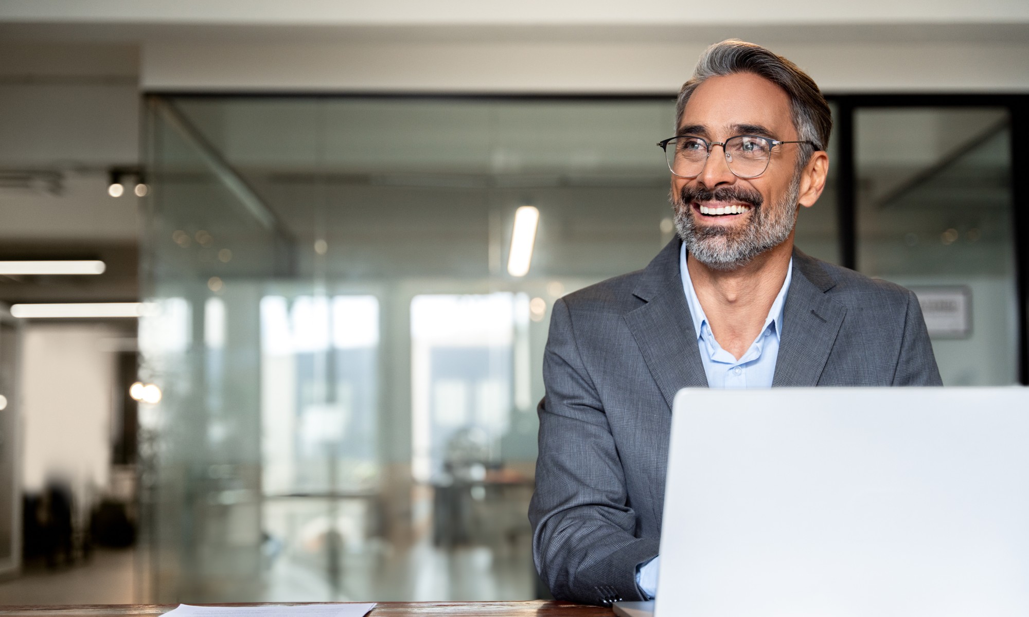 Middle aged man using laptop with AI Agents